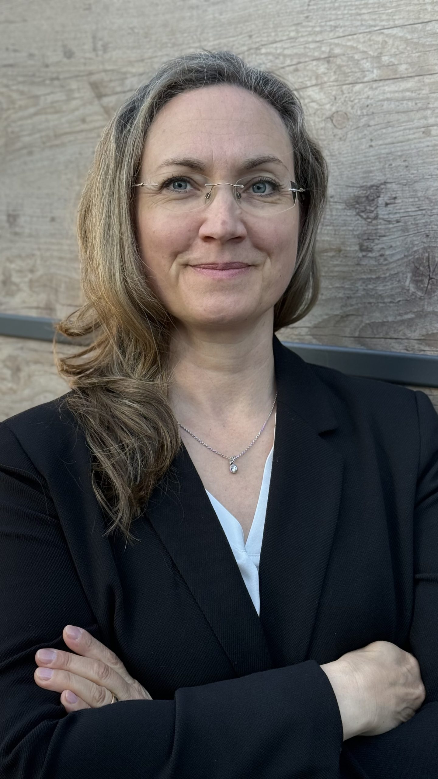 Porträt von Nadine Bergmann, Organisationsberaterin, vor einer Holzwand